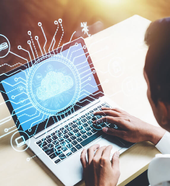 Person using laptop with digital cloud computing illustration overlaid on screen, representing digital transformation.