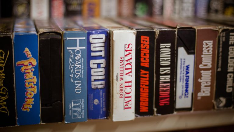 A shelf of well-used VHS movie cases.