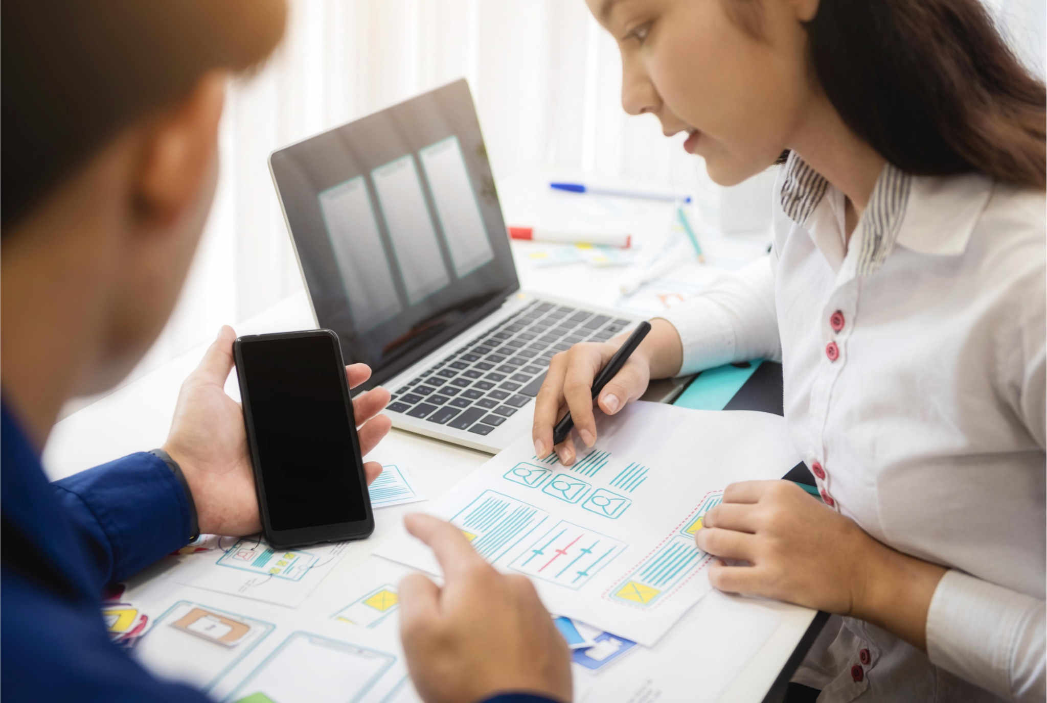 two people working over computer and phone