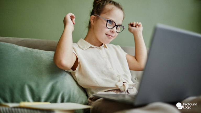 a person with glasses sitting on a couch with a laptop